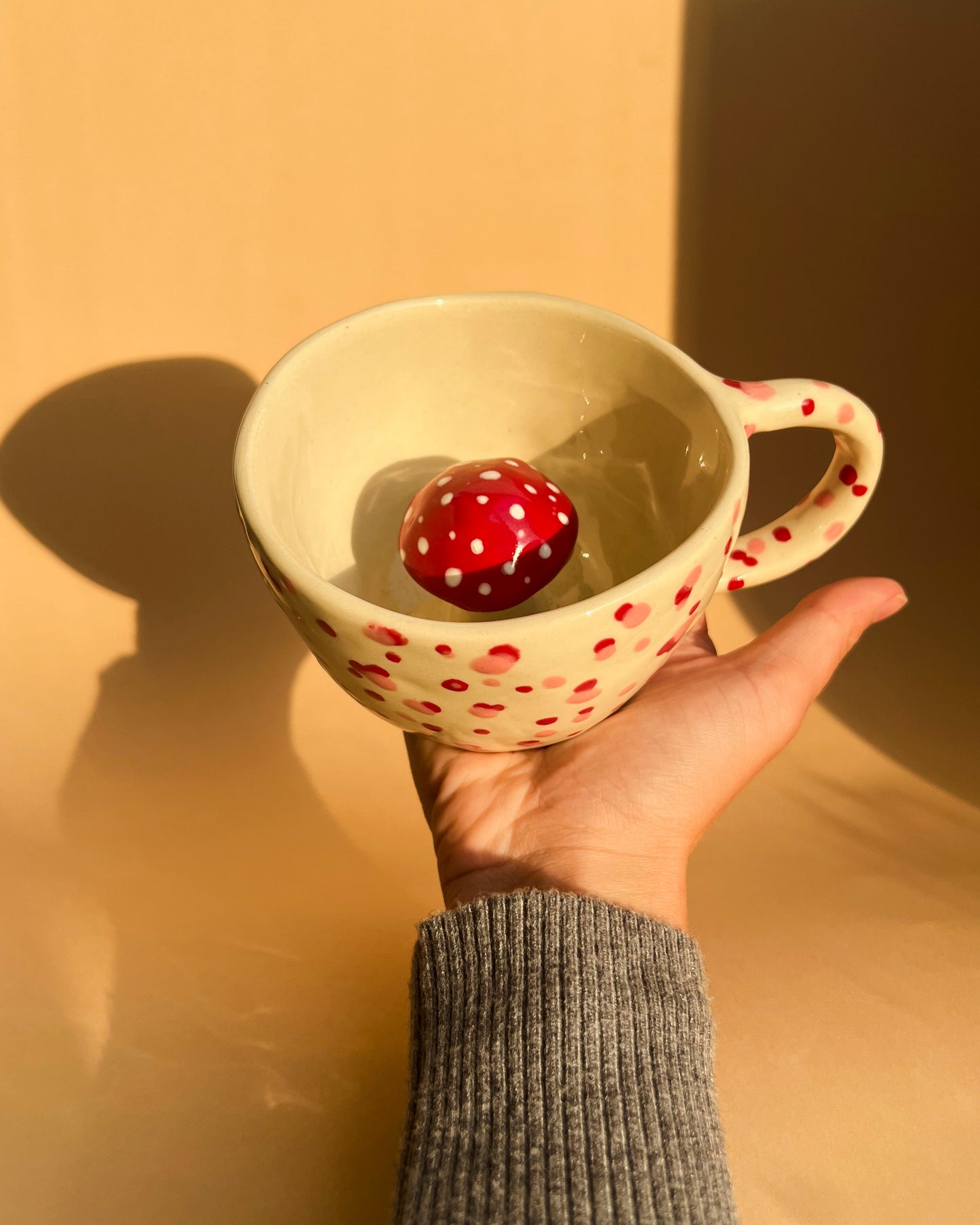 A handmade Amanita Muscaria polka dot ceramic cup from Lithuania, perfect for matcha or mushroom coffee blends like Reishi and Lion’s Mane.