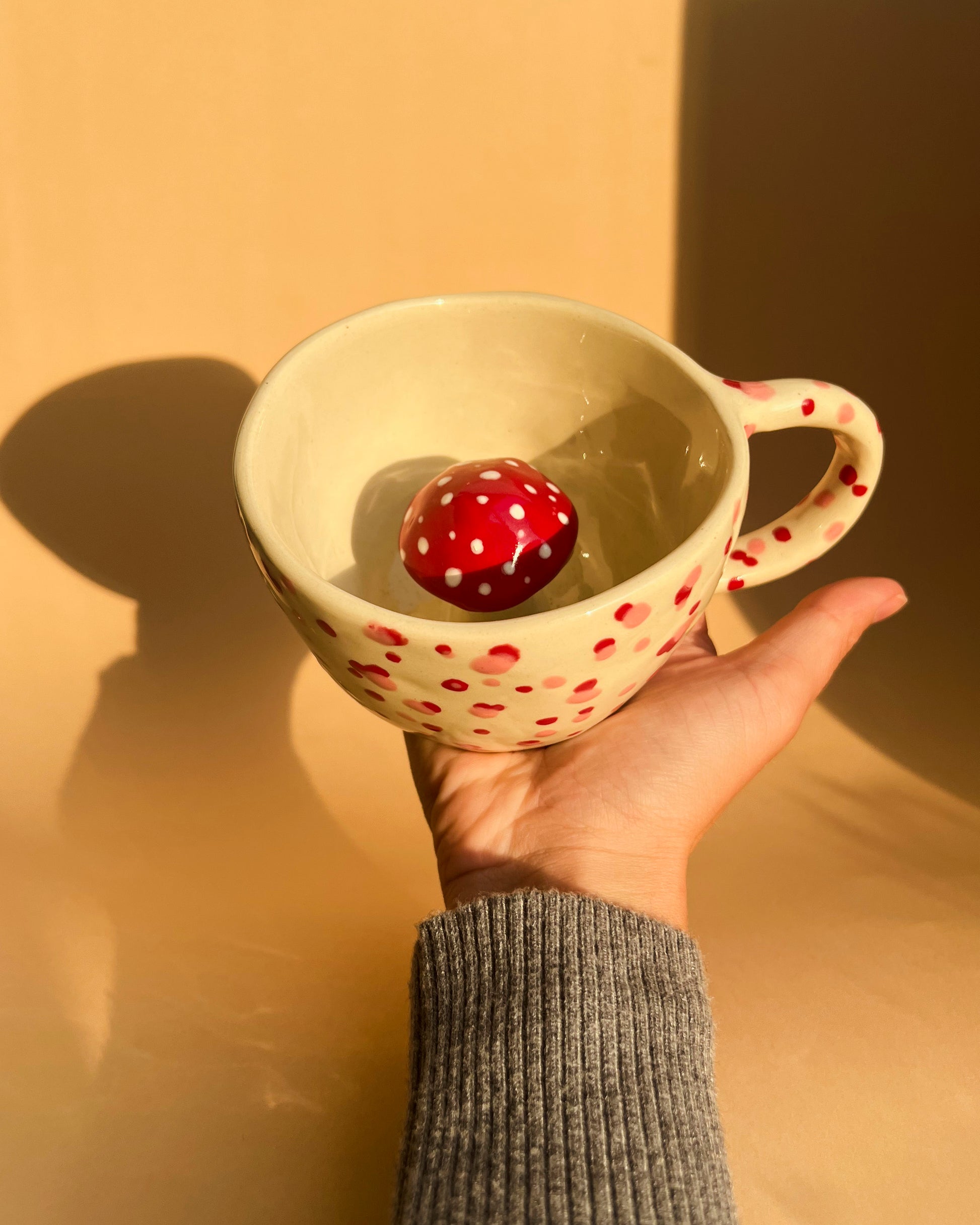 A handmade Amanita Muscaria polka dot ceramic cup from Lithuania, perfect for matcha or mushroom coffee blends like Reishi and Lion’s Mane.